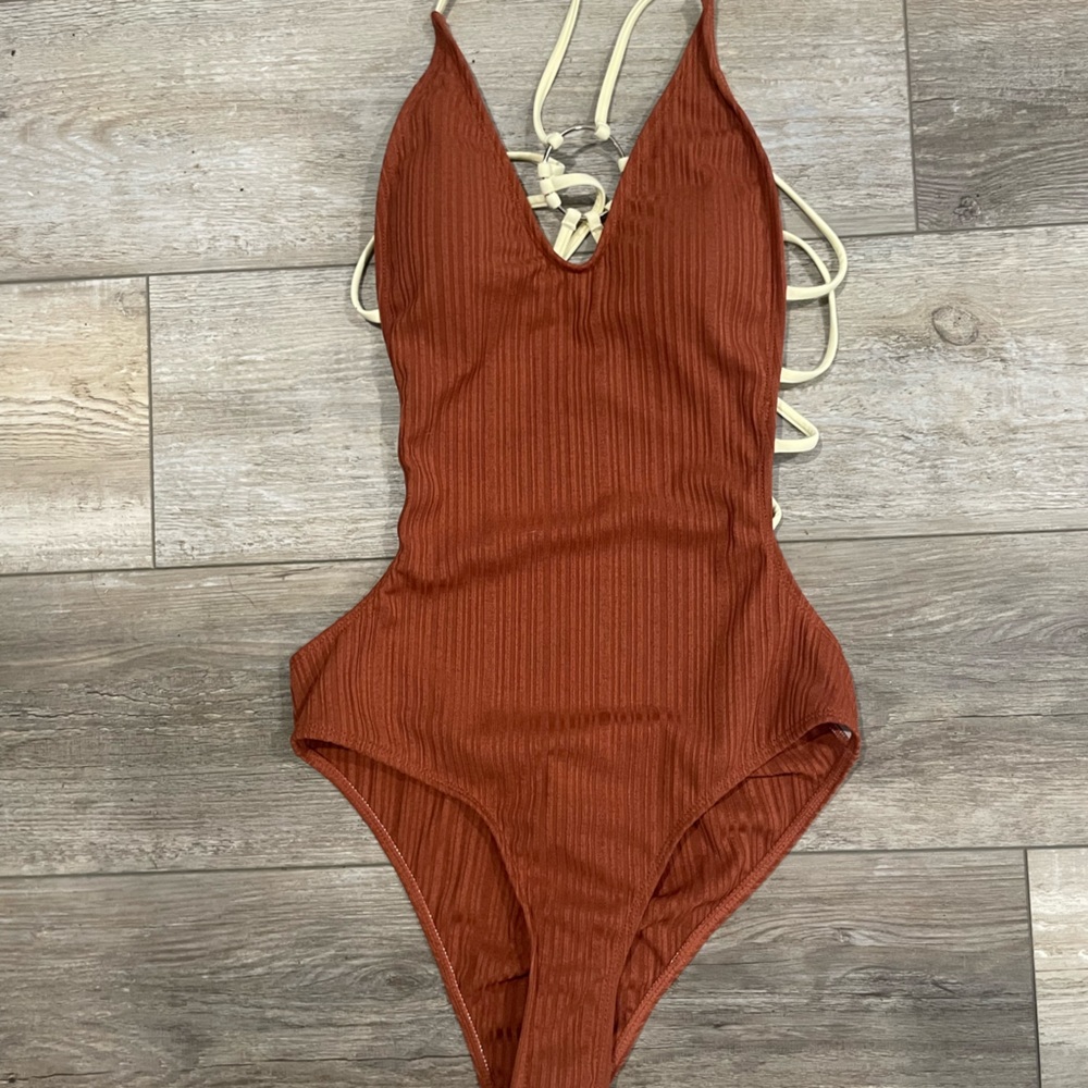 Burgundy one piece bathing suit with cream colored straps.